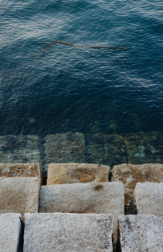 Woman sitting by waterfront